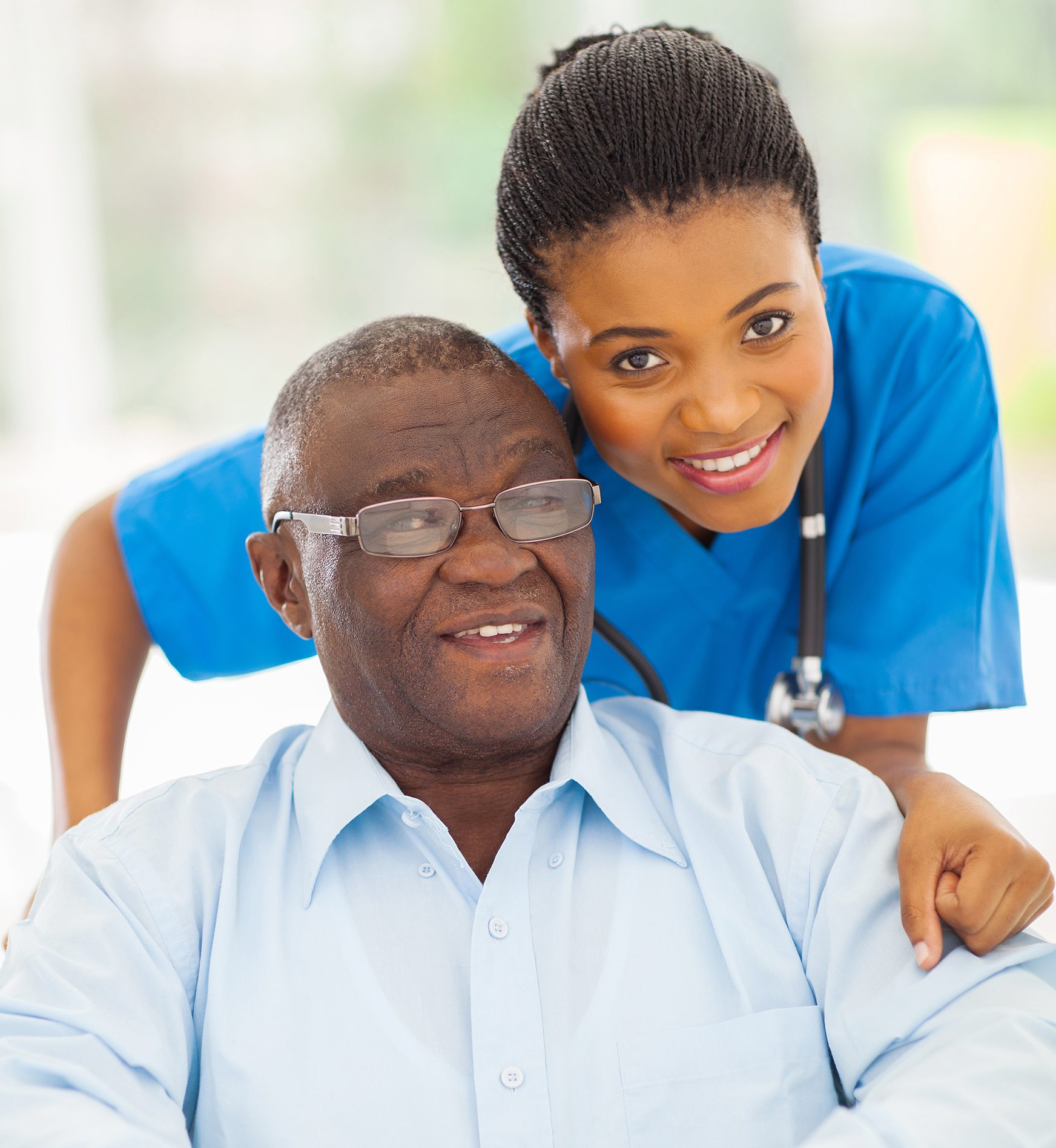elderly african american man and caring young caregiver at home